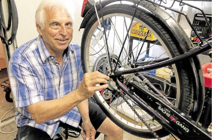 Gerd Müller repariert Fahrräder mit Geflüchteten